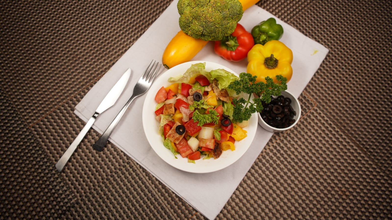 Fresh vegetables and a prepared salad bowl on a wooden table — high-protein foods to eat on glp-1 medications for weight