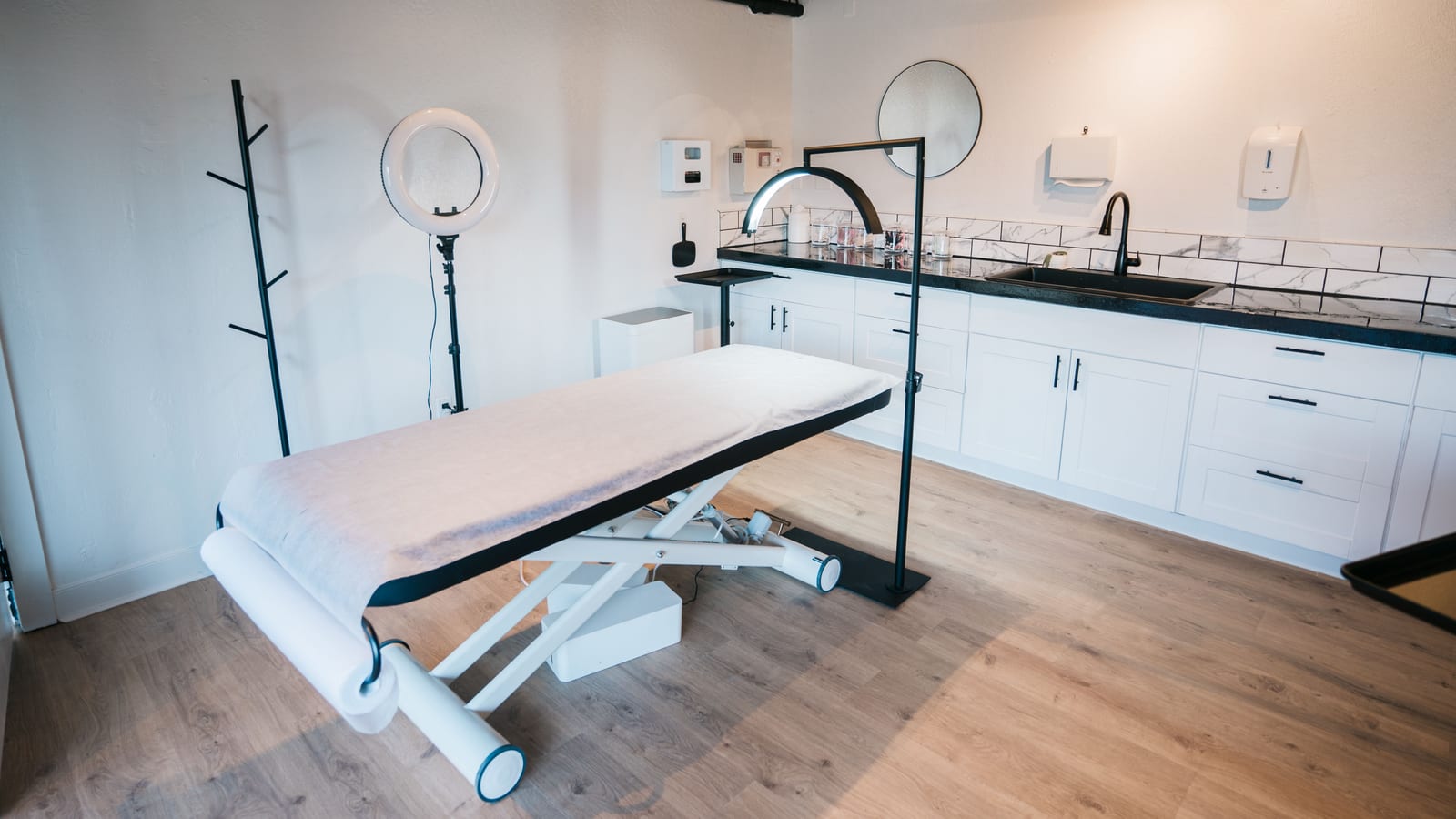 Serene med spa treatment room with a linen-draped bed and a large window — signs you're wasting time at the gym at OC Weight